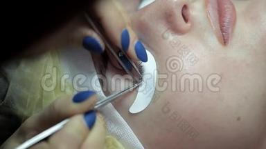 美容师在美容院执行睫毛延伸的程序。 特写
